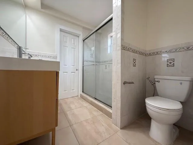 a bathroom with a granite countertop shower and a toilet