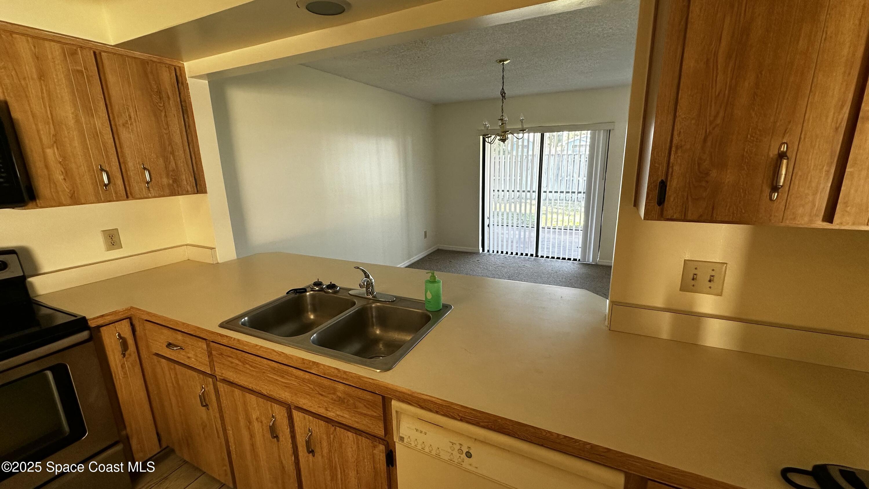 2710 Park Pl Boulevard, Unit 4 Melbourne, FL 32935 - Photo 14 of 16 a kitchen with a sink a stove and cabinets