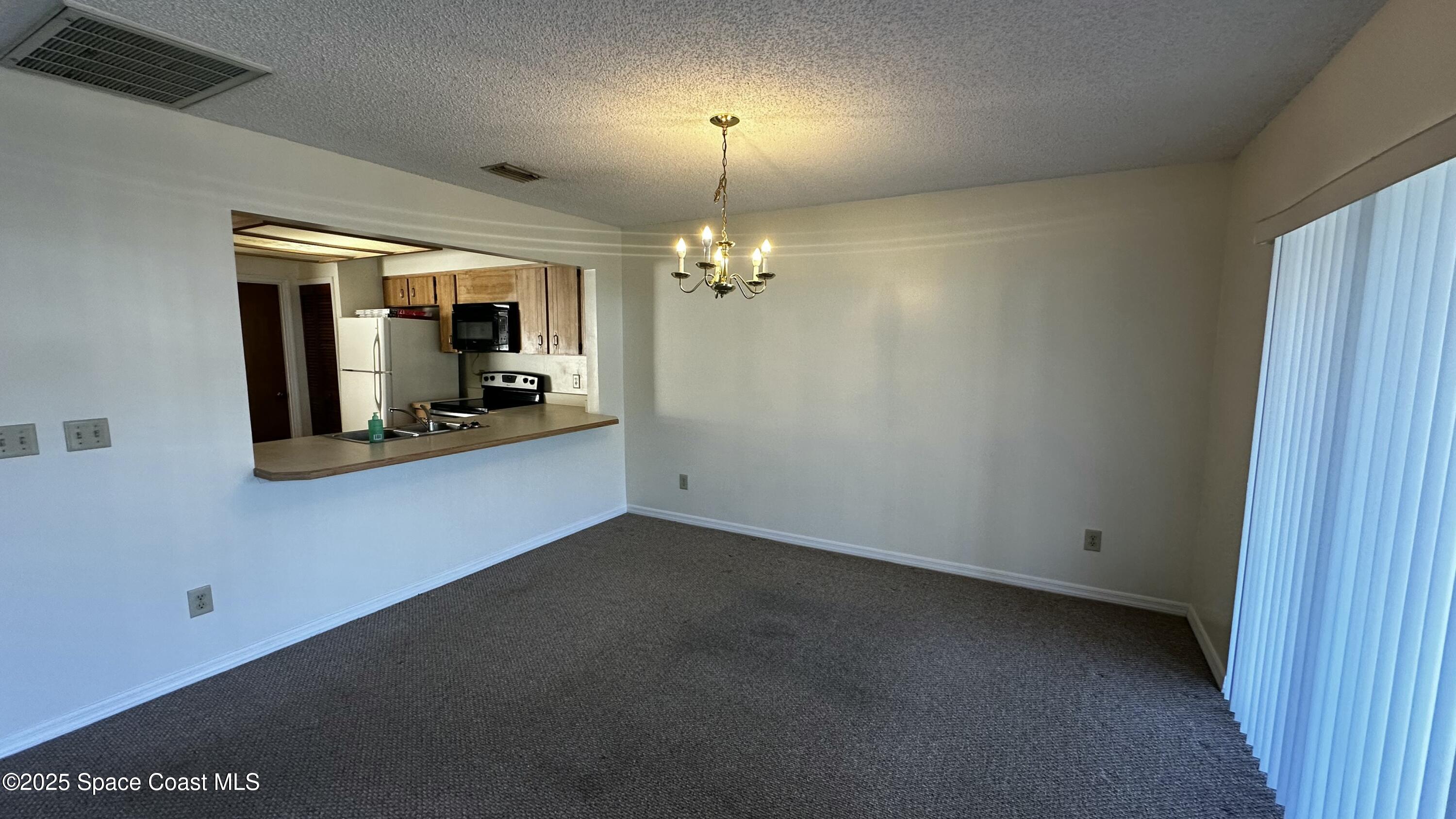 2710 Park Pl Boulevard, Unit 4 Melbourne, FL 32935 - Photo 6 of 16 a view of a room with a chandelier