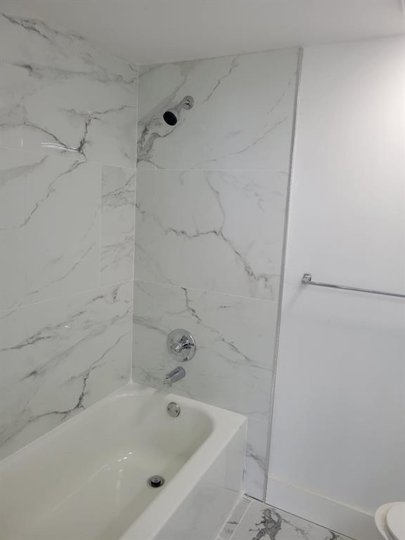 4222 Inverrary Boulevard, Unit 4413 Lauderhill, FL 33319 - Photo 21 of 34 a white bath tub sitting next to a white sink and vanity