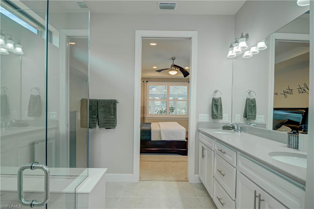 7938 Guadiana Way Ave Maria, FL 34142 - Photo 15 of 37 a bathroom with a sink a large mirror and a shower