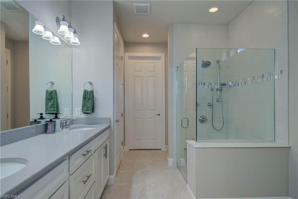 7938 Guadiana Way Ave Maria, FL 34142 - Photo 16 of 37 a bathroom with a double vanity sink mirror and shower