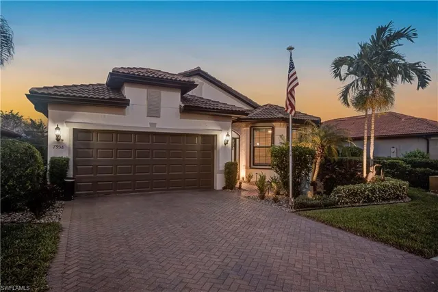 a view of a house with a small yard and potted plants