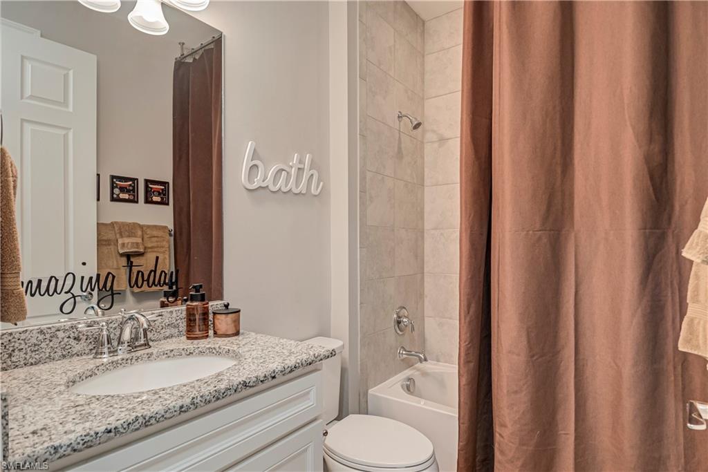 7938 Guadiana Way Ave Maria, FL 34142 - Photo 35 of 37 a bathroom with a granite countertop sink toilet and shower