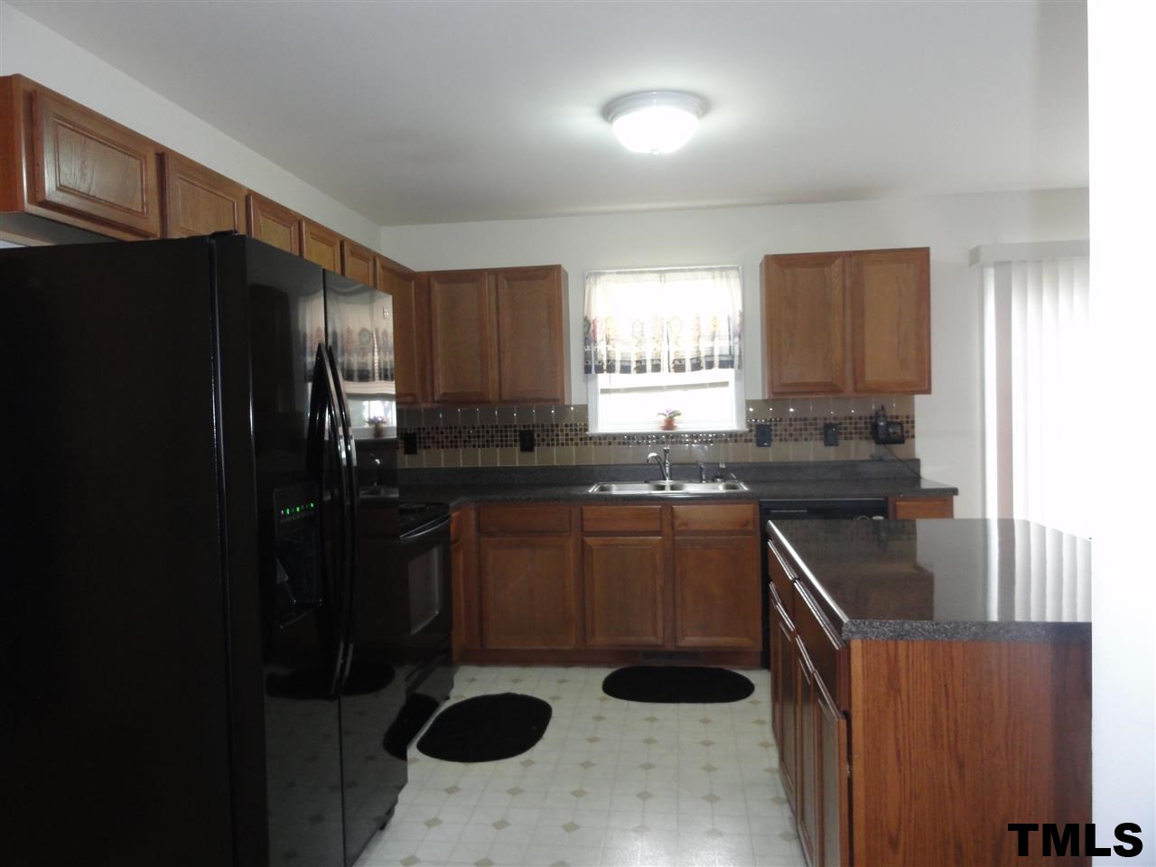 904 Morning Still Court Rolesville, NC 27571 - Photo 5 of 25 a kitchen with a sink a refrigerator and window
