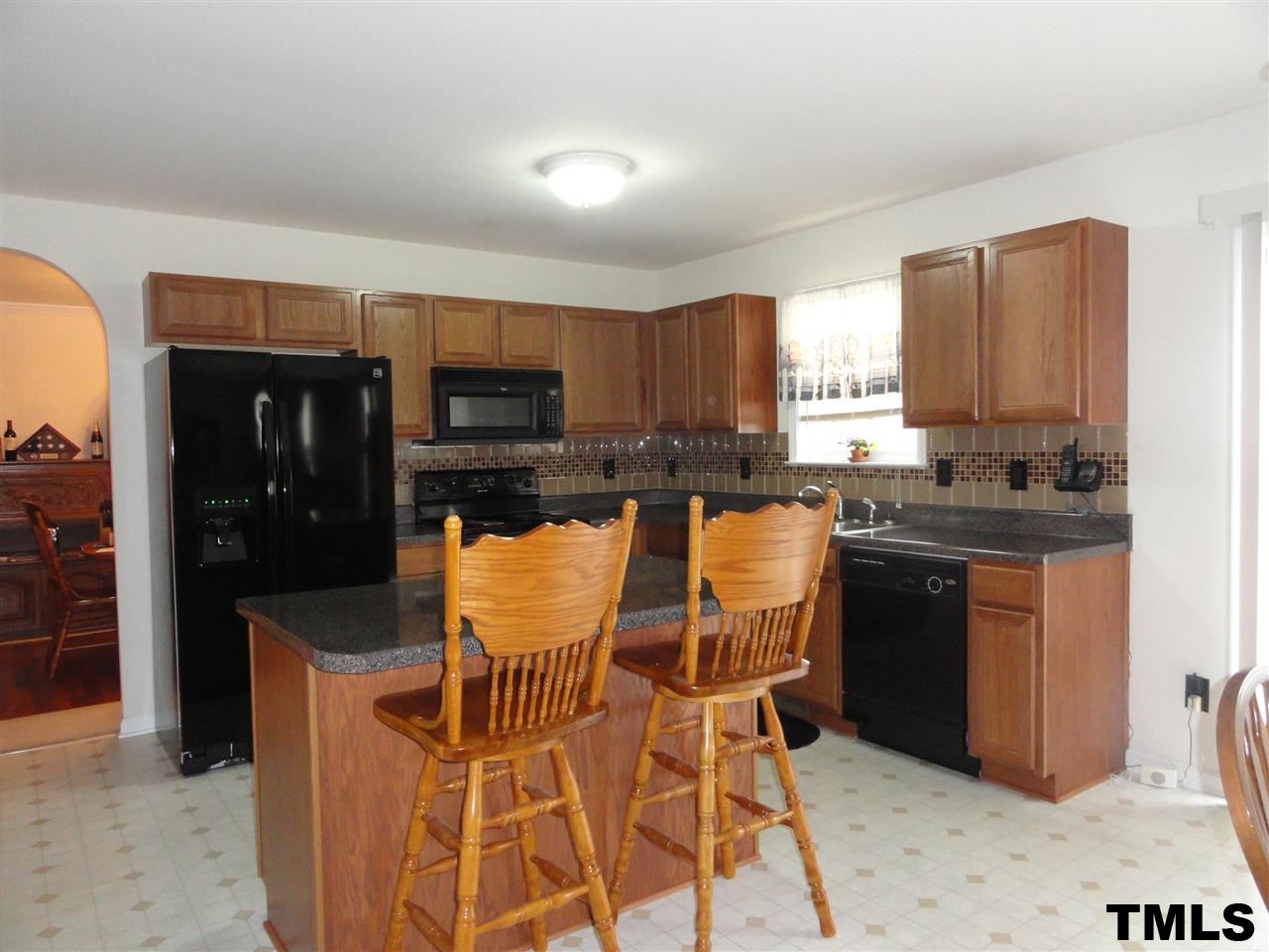 904 Morning Still Court Rolesville, NC 27571 - Photo 6 of 25 a kitchen with kitchen island granite countertop a stove top oven microwave and refrigerator