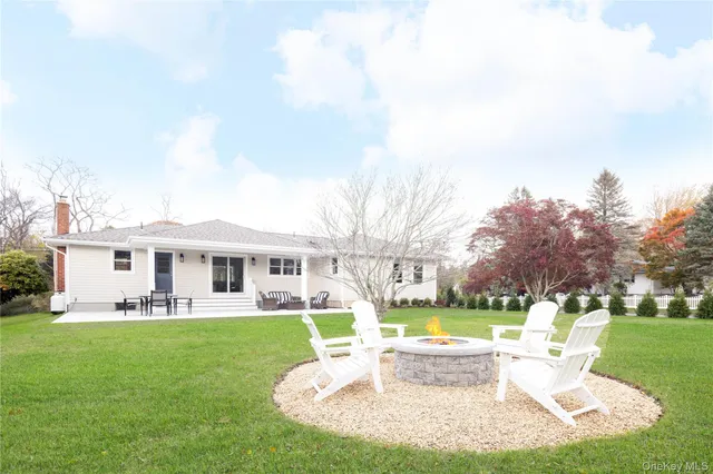 a view of a house with a big yard potted plants and large tree