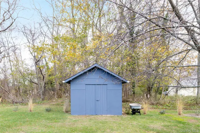 a view of backyard with wooden fence and large trees