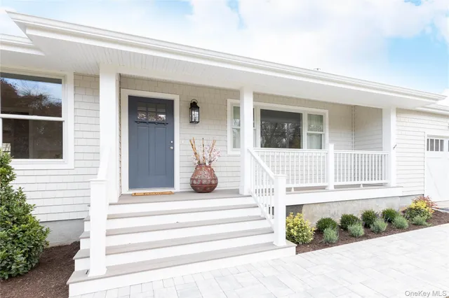 a front view of a house with potted plants and wooden floor