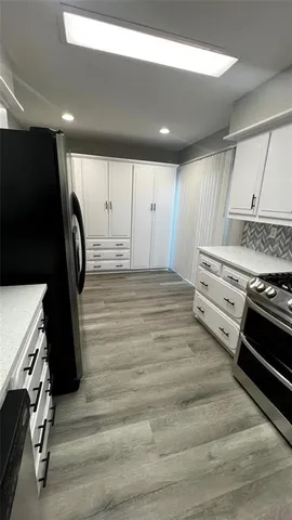 a view of kitchen with stainless steel appliances granite countertop a stove and a refrigerator