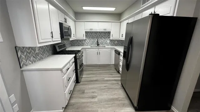 a kitchen with a refrigerator a sink and dishwasher