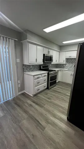 a kitchen with stainless steel appliances granite countertop a stove top oven a sink and a granite counter tops