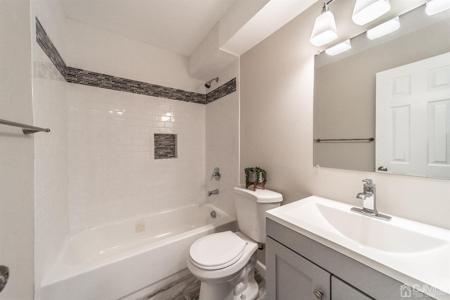 15 Dayton Road Edison, NJ 08817 - Photo 13 of 28 a bathroom with a toilet a sink a mirror a bathtub and vanity
