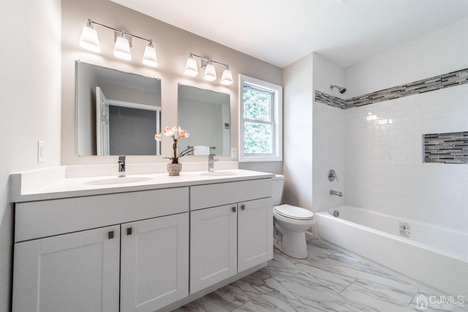 15 Dayton Road Edison, NJ 08817 - Photo 21 of 28 a bathroom with a double vanity sink toilet mirror and bathtub
