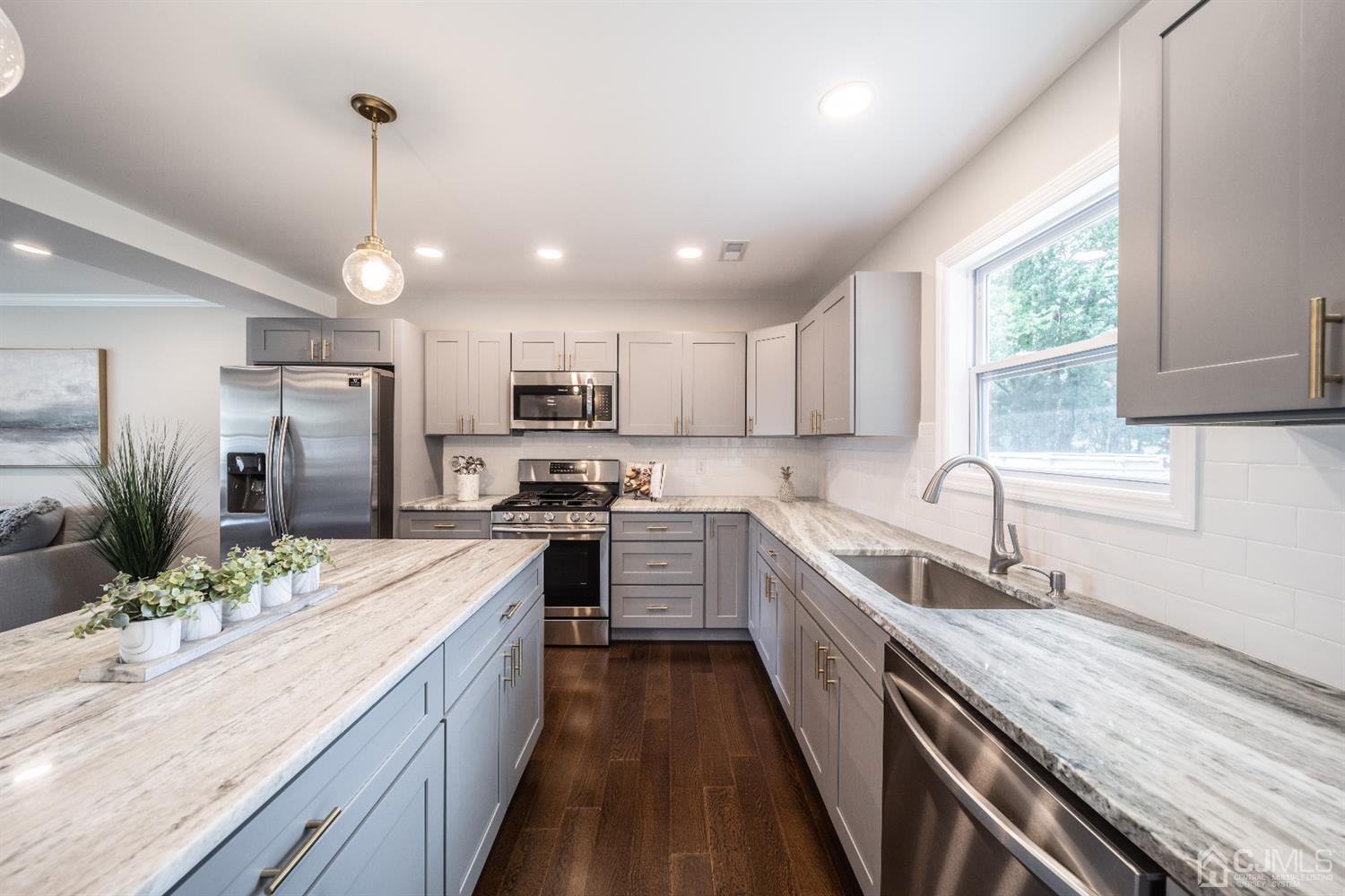 15 Dayton Road Edison, NJ 08817 - Photo 8 of 28 a kitchen with a sink a counter top space stainless steel appliances and windows