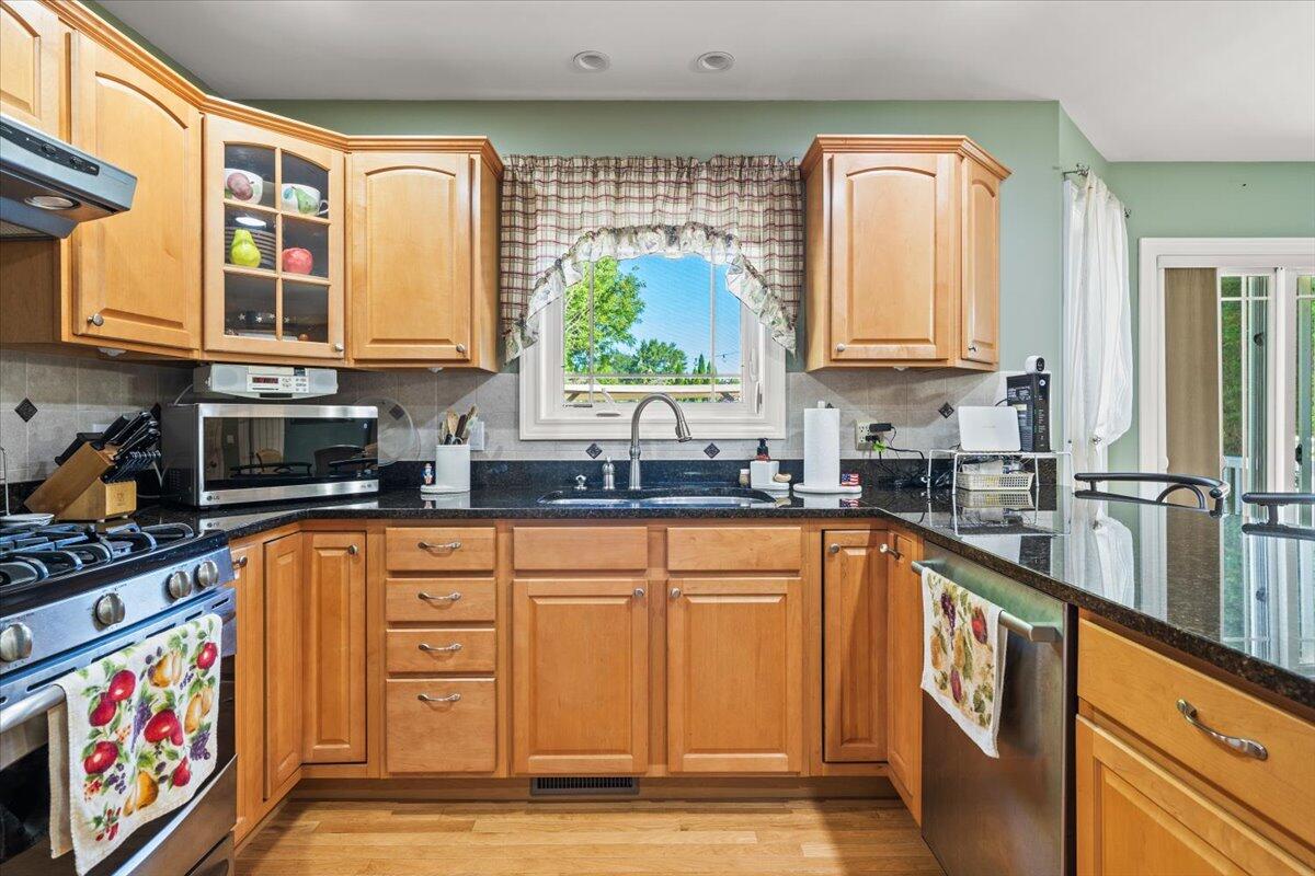 1270 East Greenview Place Crown Point, IN 46307 - Photo 11 of 44 a kitchen with stainless steel appliances granite countertop a stove a sink and a microwave