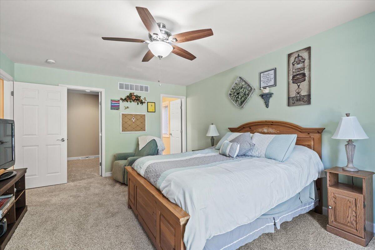 1270 East Greenview Place Crown Point, IN 46307 - Photo 16 of 44 a bedroom with a large bed and a chandelier