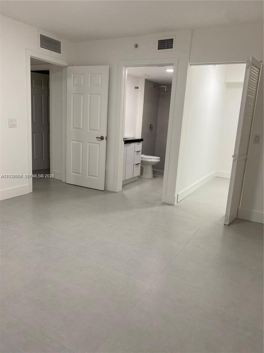 15480 Southwest 284th Street, Unit 2203 Homestead, FL 33033 - Photo 12 of 13 an empty room with mirror and a sink