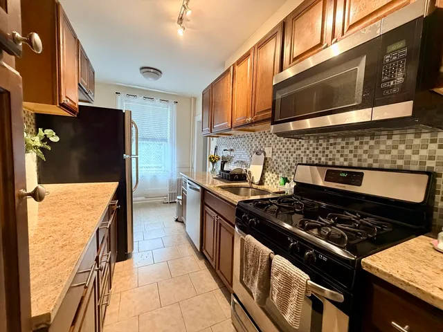 a kitchen with stainless steel appliances granite countertop a stove and a refrigerator