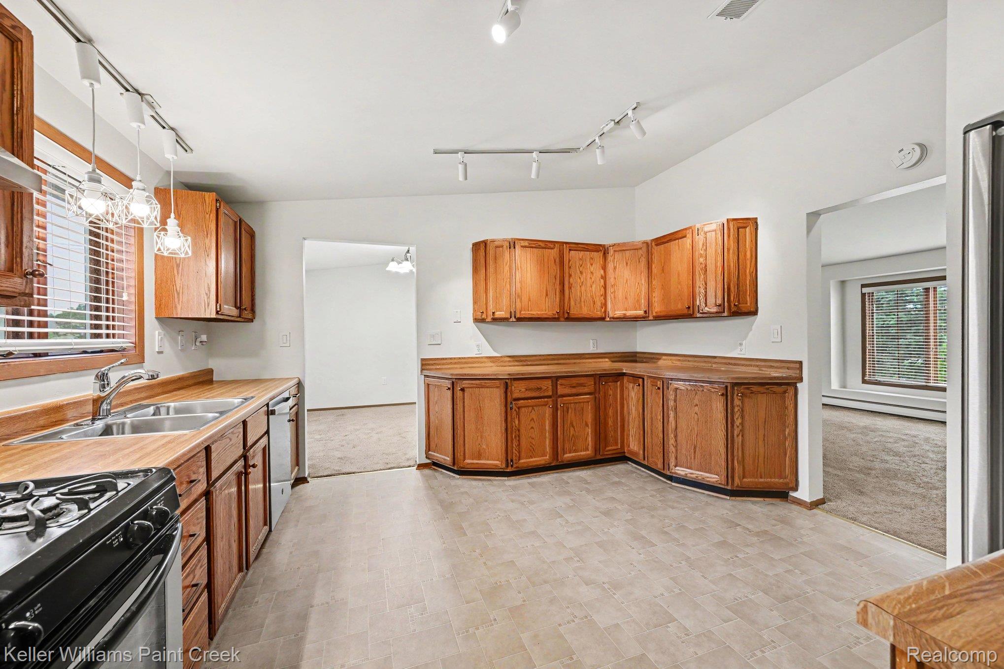 2232 London Bridge Drive Rochester, MI 48307 - Photo 13 of 26 Kitchen featuring wood cabinetry, wood-finish countertops, stainless steel sink with dual basins, and track lighting