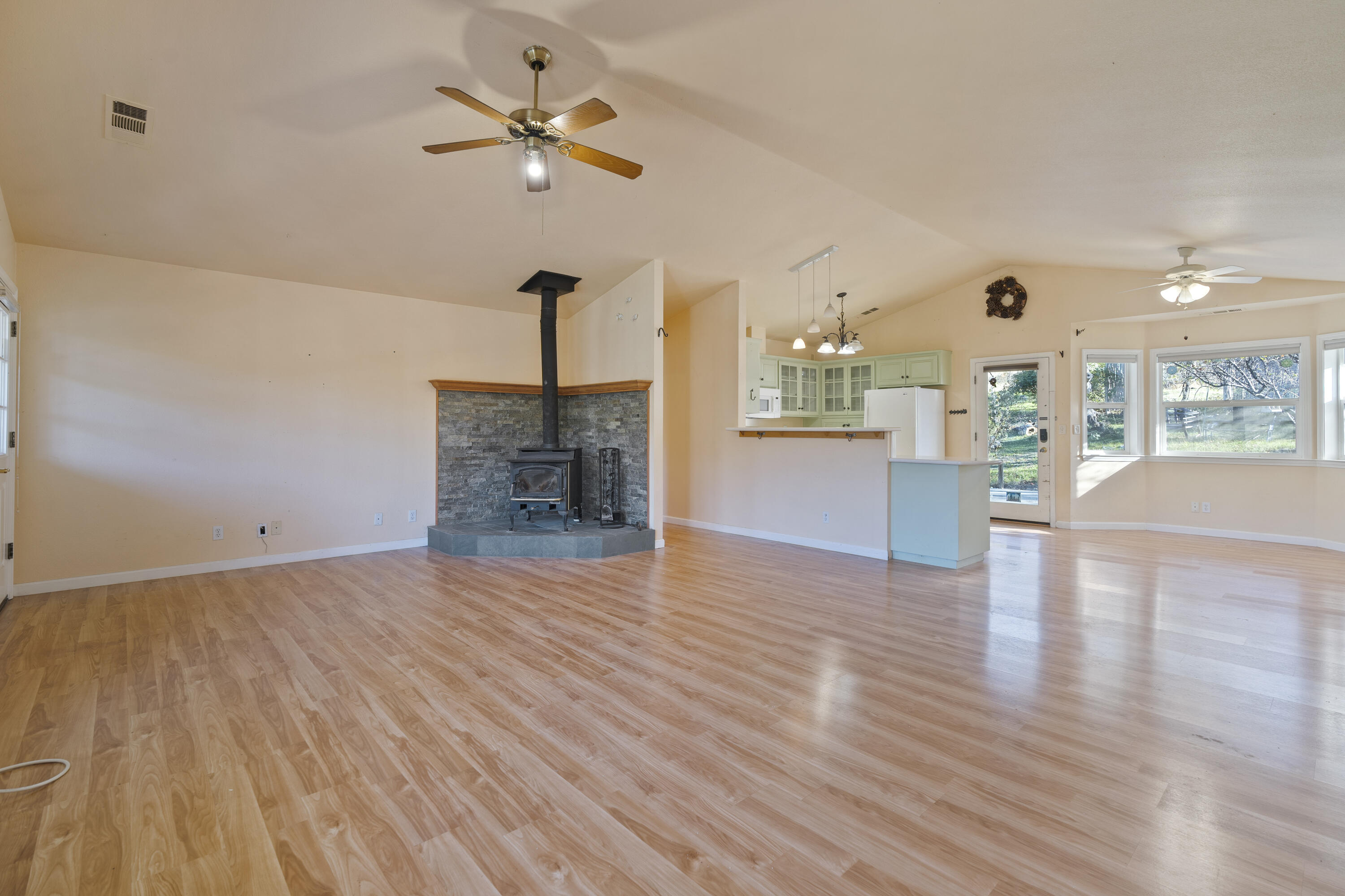 6841 Vista Lavega Road Shingletown, CA 96088 - Photo 14 of 57 a view of a livingroom with a fireplace a chandelier a wooden table and chairs