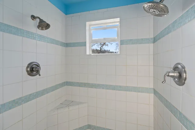 a backyard of a house with large trees and covered by side of the house