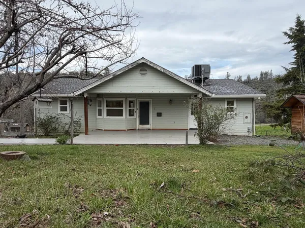 a view of an empty room with wooden floor a ceiling fan and windows