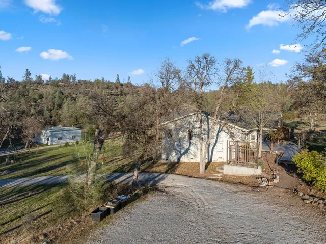 a view of a livingroom with a fireplace a chandelier a wooden table and chairs