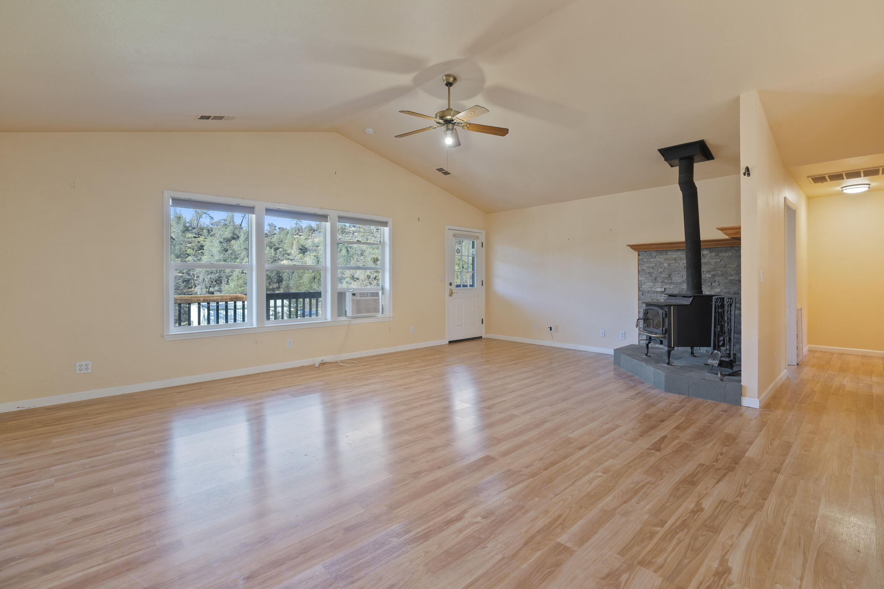 6841 Vista Lavega Road Shingletown, CA 96088 - Photo 8 of 57 a view of an empty room with wooden floor a ceiling fan and windows