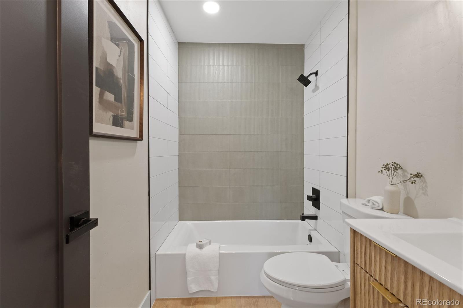 9458 Flower Street Broomfield, CO 80021 - Photo 18 of 30 a bathroom with a toilet a sink and bathtub