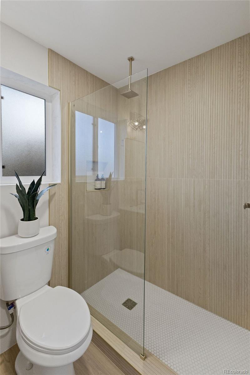 9458 Flower Street Broomfield, CO 80021 - Photo 22 of 30 a white toilet sitting next to a bathroom sink