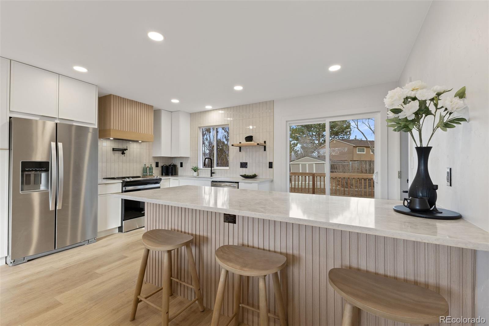 9458 Flower Street Broomfield, CO 80021 - Photo 4 of 30 a kitchen with refrigerator and cabinets