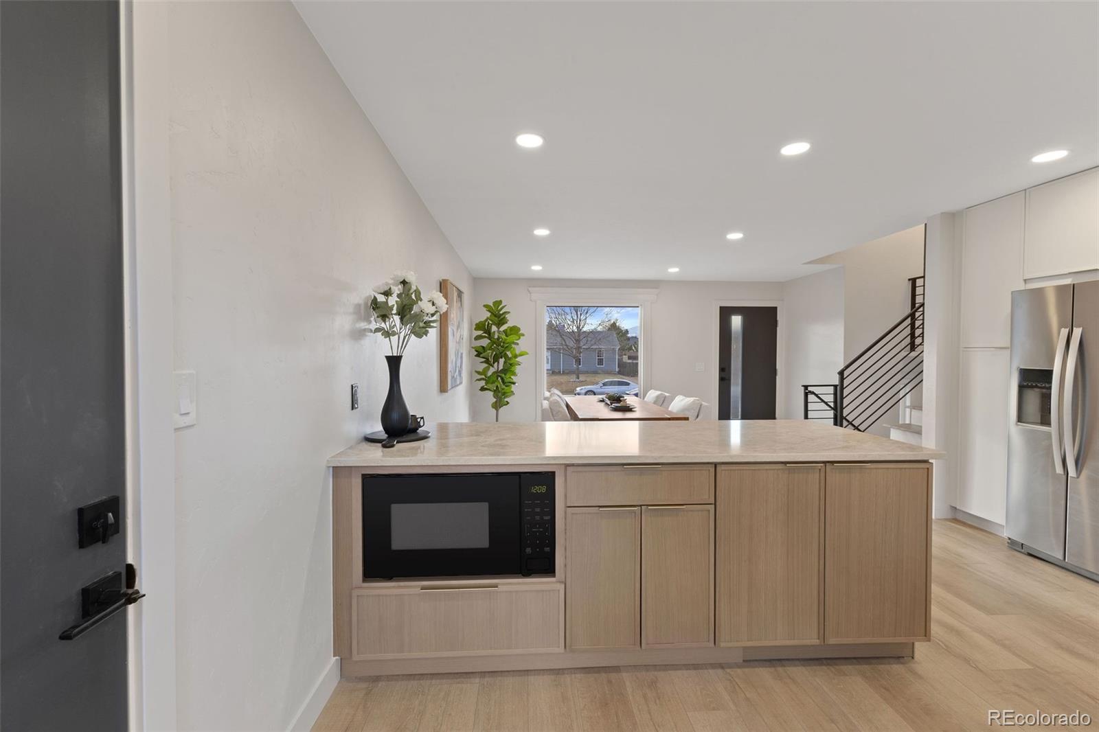 9458 Flower Street Broomfield, CO 80021 - Photo 5 of 30 a room with kitchen island stainless steel appliances a sink and cabinets