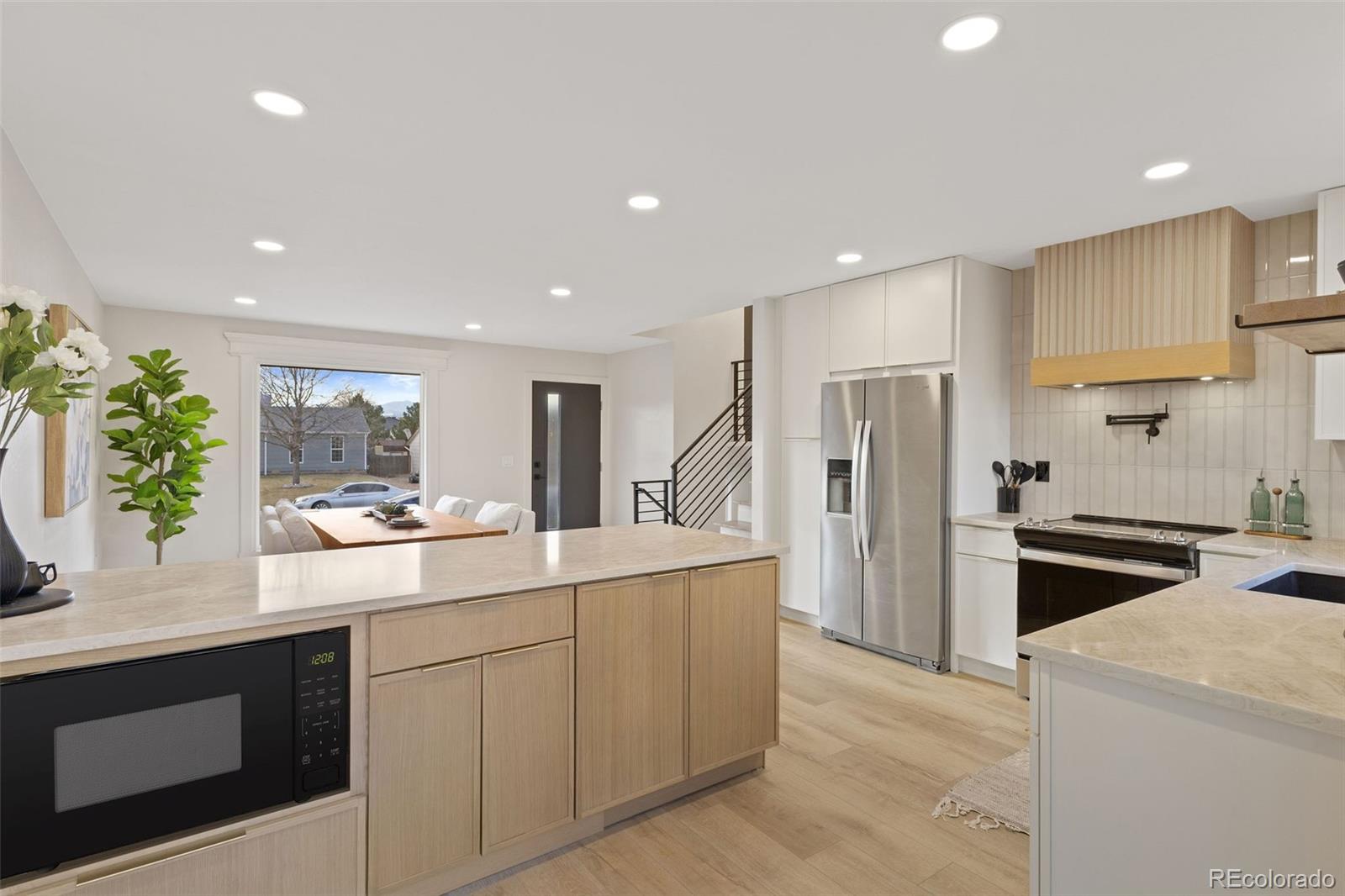 9458 Flower Street Broomfield, CO 80021 - Photo 6 of 30 a kitchen with white cabinets and stainless steel appliances