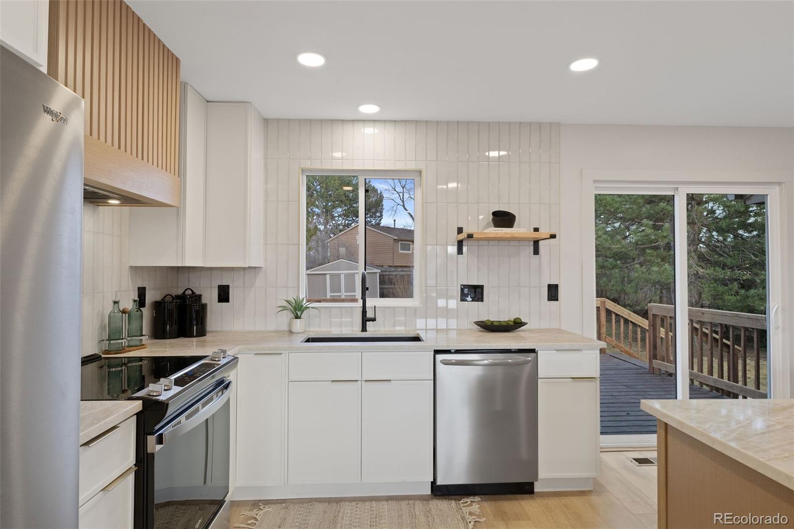 9458 Flower Street Broomfield, CO 80021 - Photo 8 of 30 a kitchen that has a sink a stove and cabinets