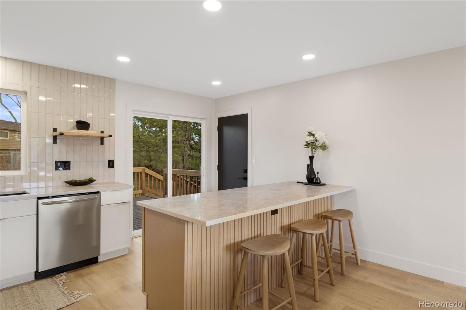 9458 Flower Street Broomfield, CO 80021 - Photo 9 of 30 a kitchen with stainless steel appliances granite countertop a stove and a refrigerator