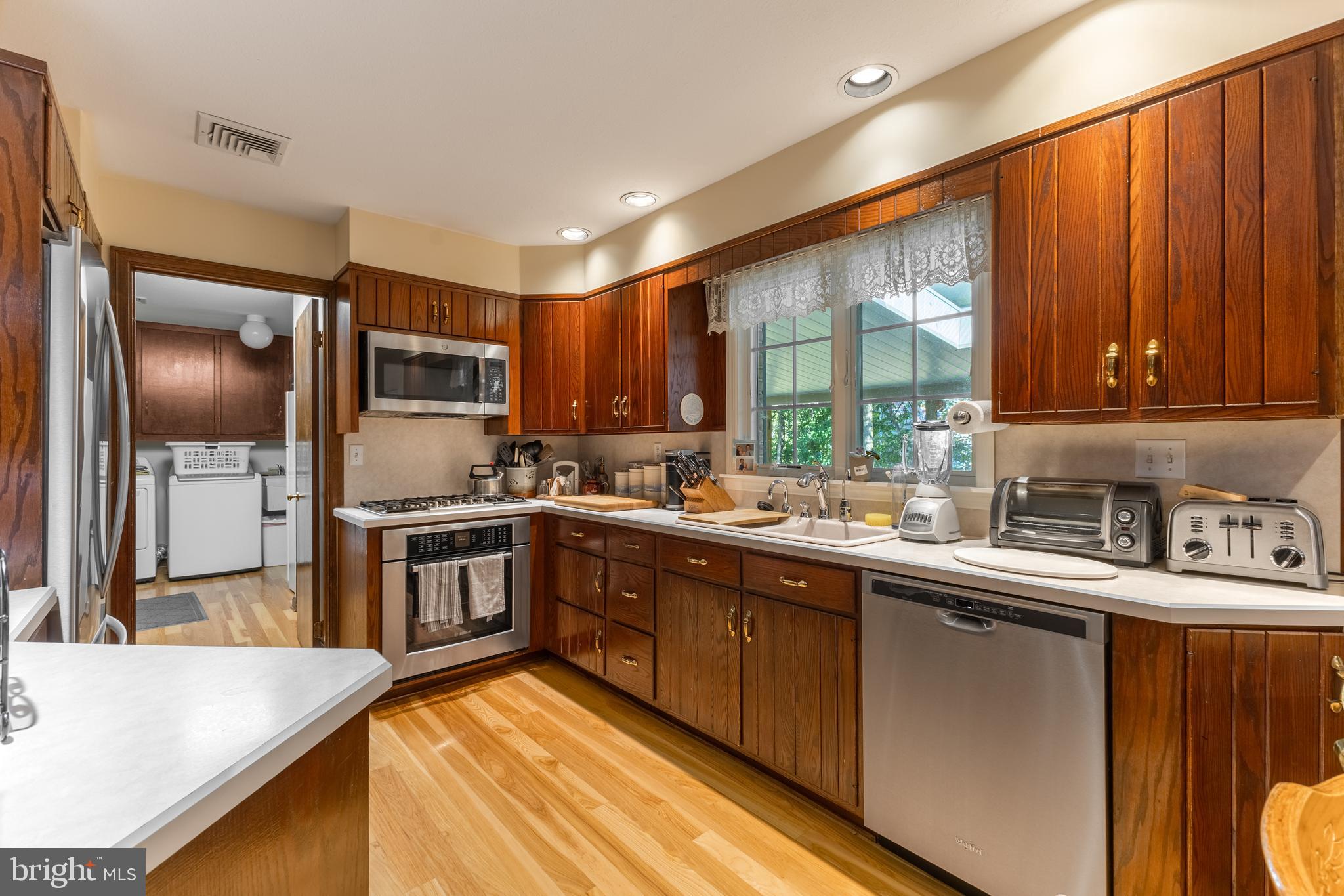 212 Seneca Circle State College, PA 16801 - Photo 38 of 67 a kitchen with stainless steel appliances granite countertop a refrigerator a sink dishwasher a stove and white countertops with wooden floor