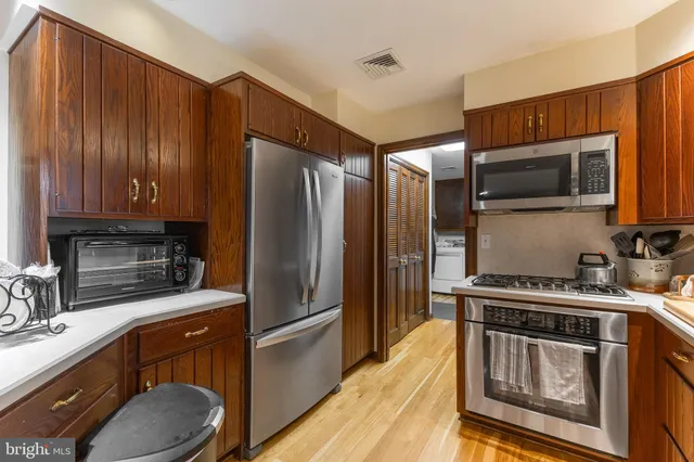 a kitchen with stainless steel appliances kitchen island granite countertop a sink and cabinets