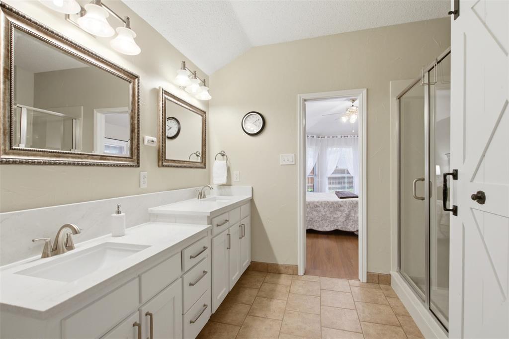 4218 Glistening Spring Rowlett, TX 75088 - Photo 21 of 39 Dual vanity with white cabinetry, integrated sinks, and brushed nickel faucets