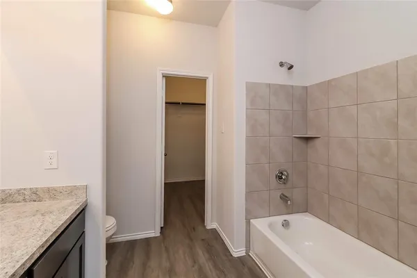 a bathroom with a granite countertop sink a toilet and shower