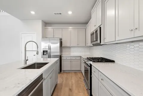 a kitchen with stainless steel appliances granite countertop a sink stove and refrigerator