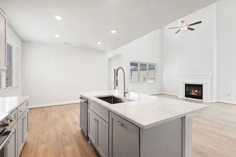 a kitchen with kitchen island granite countertop appliances cabinets and a sink