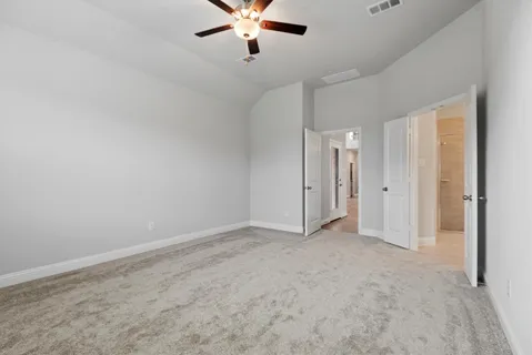 an empty room with a window and a ceiling fan