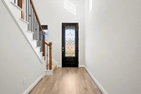 a view of hallway with stairs and wooden floor