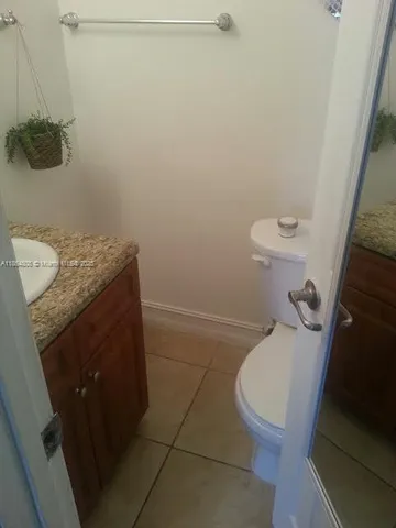 a bathroom with a granite countertop toilet and a sink