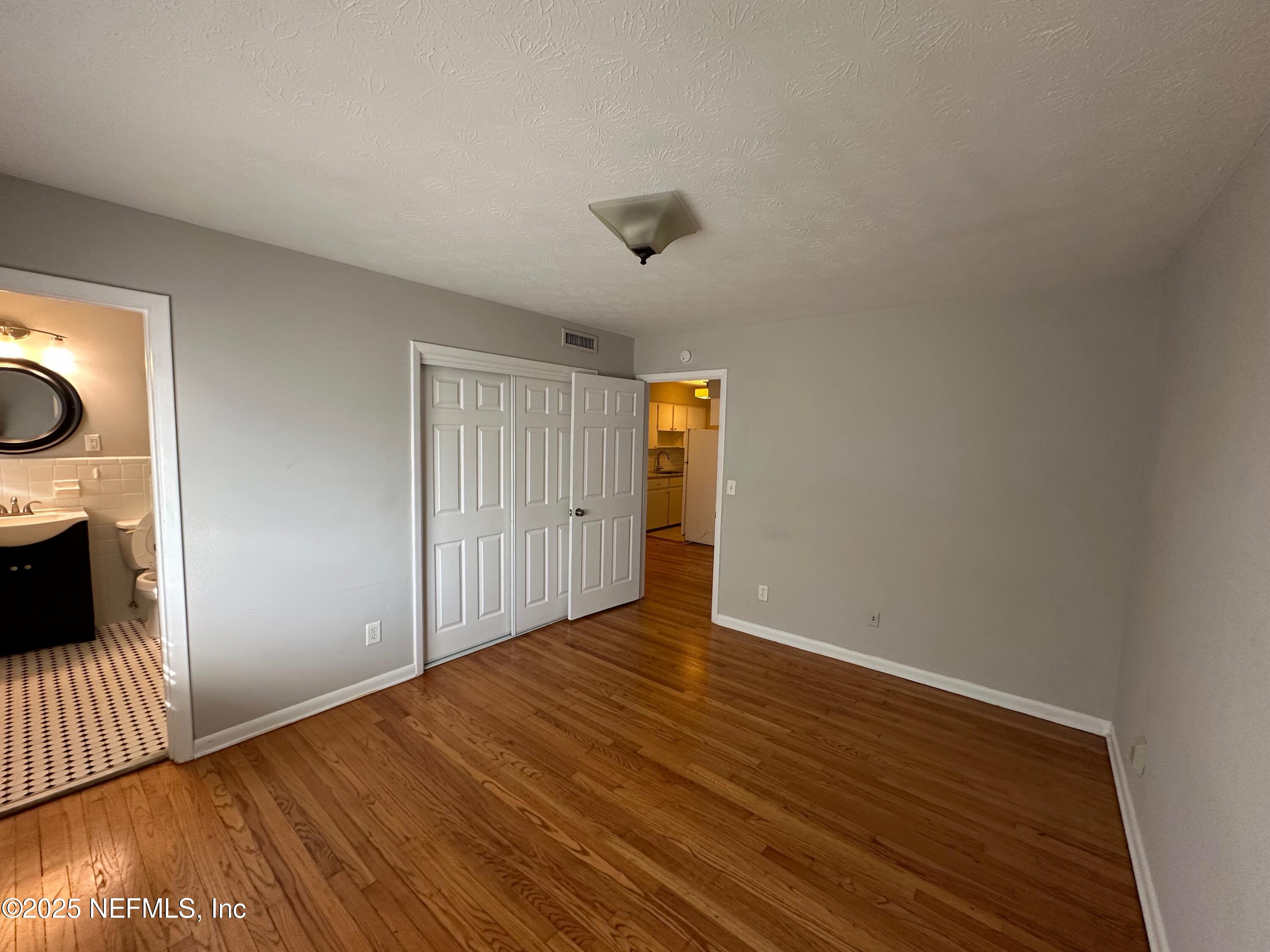 1120 Cedar Street, Unit F Jacksonville, FL 32207 - Photo 12 of 19 a view of an empty room with wooden floor and a window