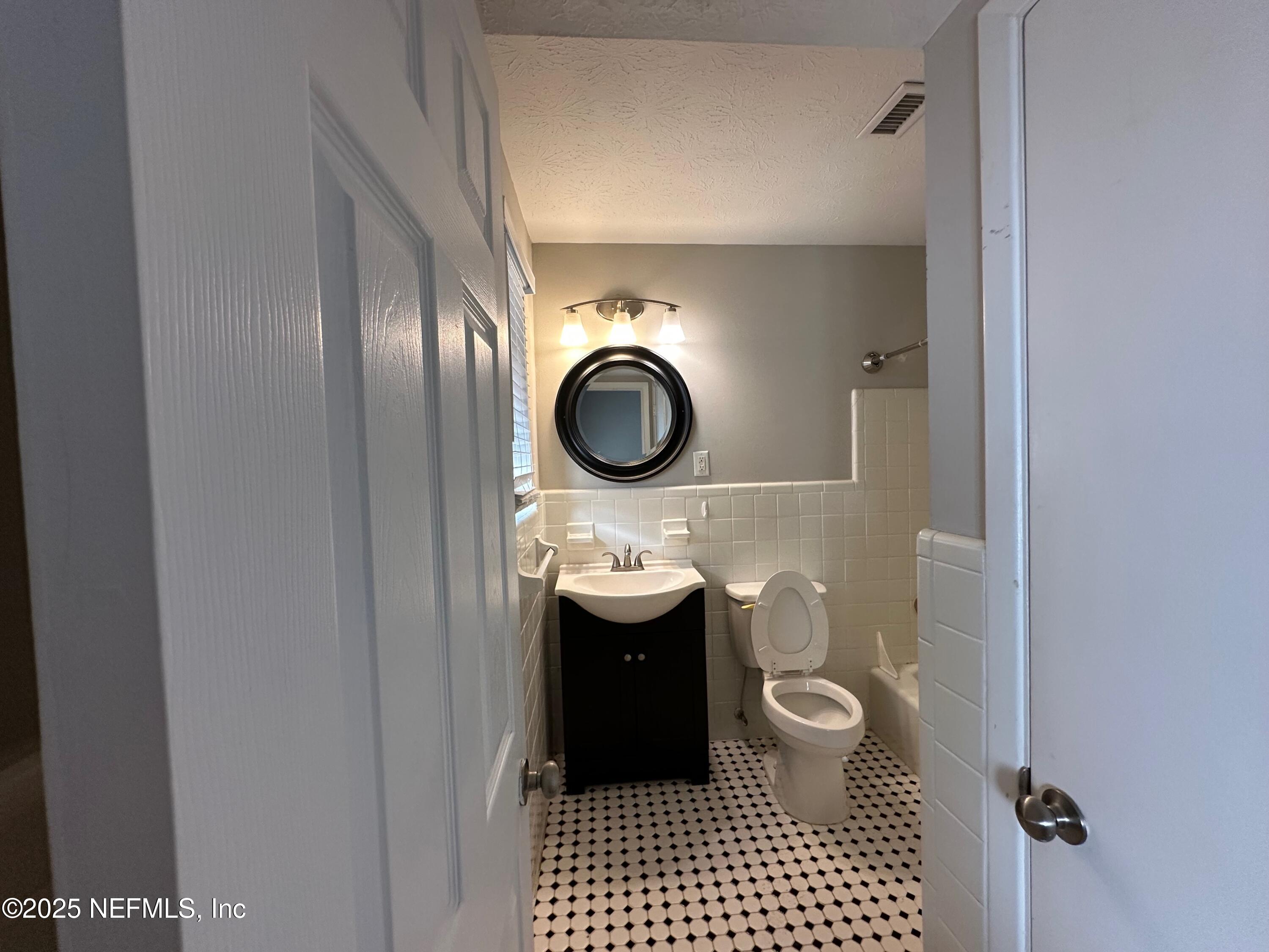 1120 Cedar Street, Unit F Jacksonville, FL 32207 - Photo 14 of 19 a bathroom with a toilet a sink and mirror
