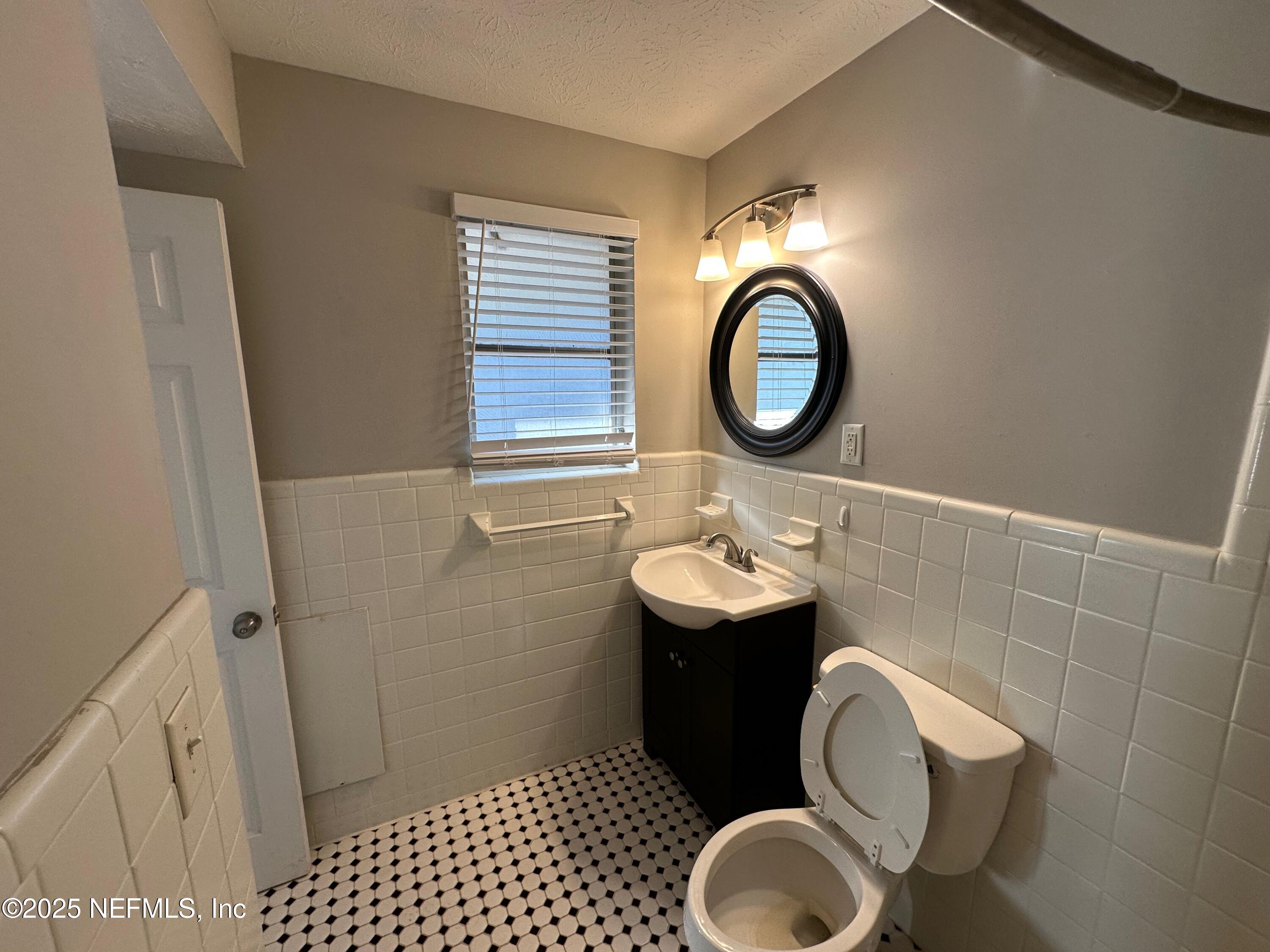 1120 Cedar Street, Unit F Jacksonville, FL 32207 - Photo 16 of 19 a bathroom with a toilet mirror vanity and a sink