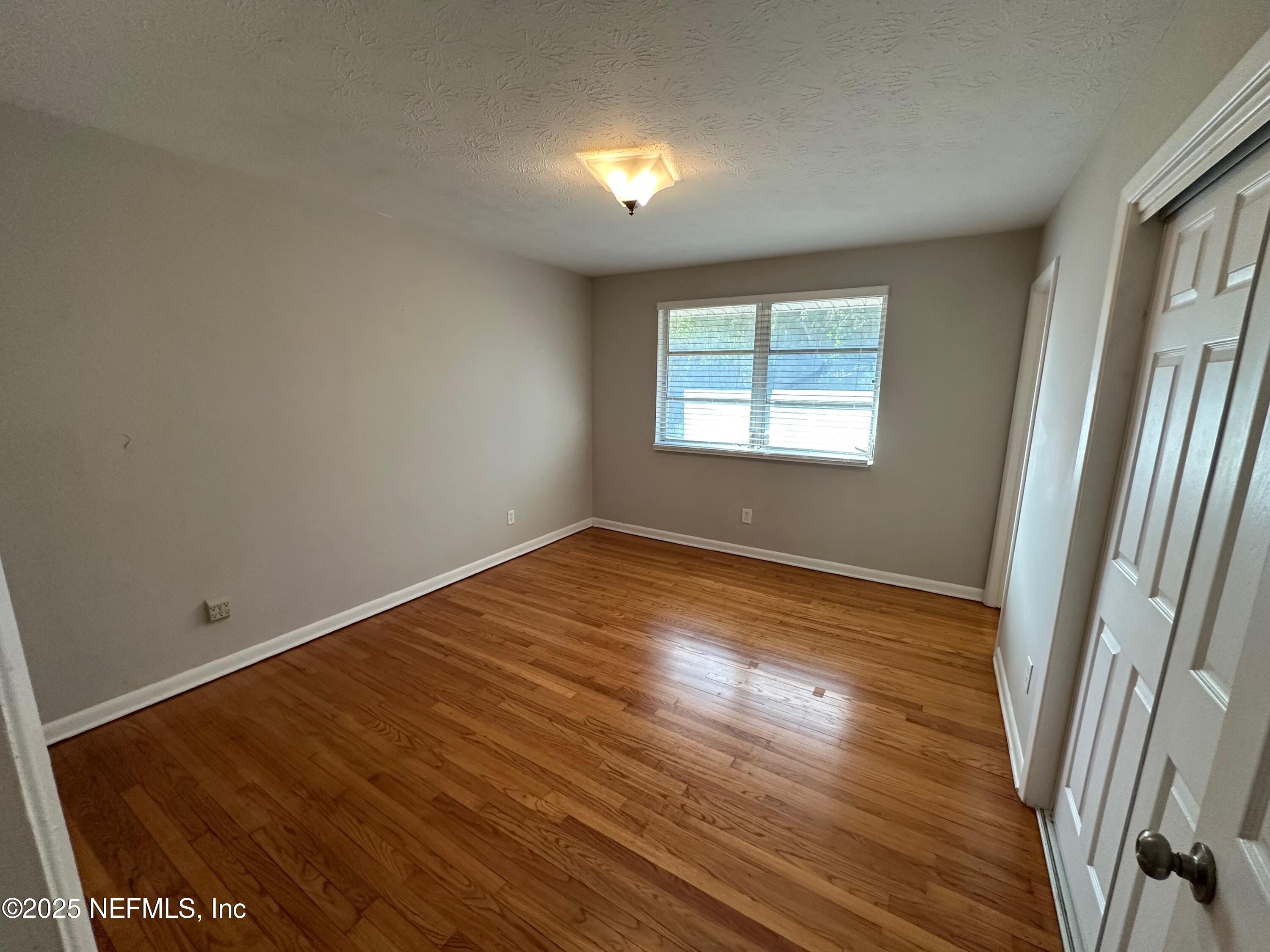 1120 Cedar Street, Unit F Jacksonville, FL 32207 - Photo 17 of 19 an empty room with wooden floor and windows