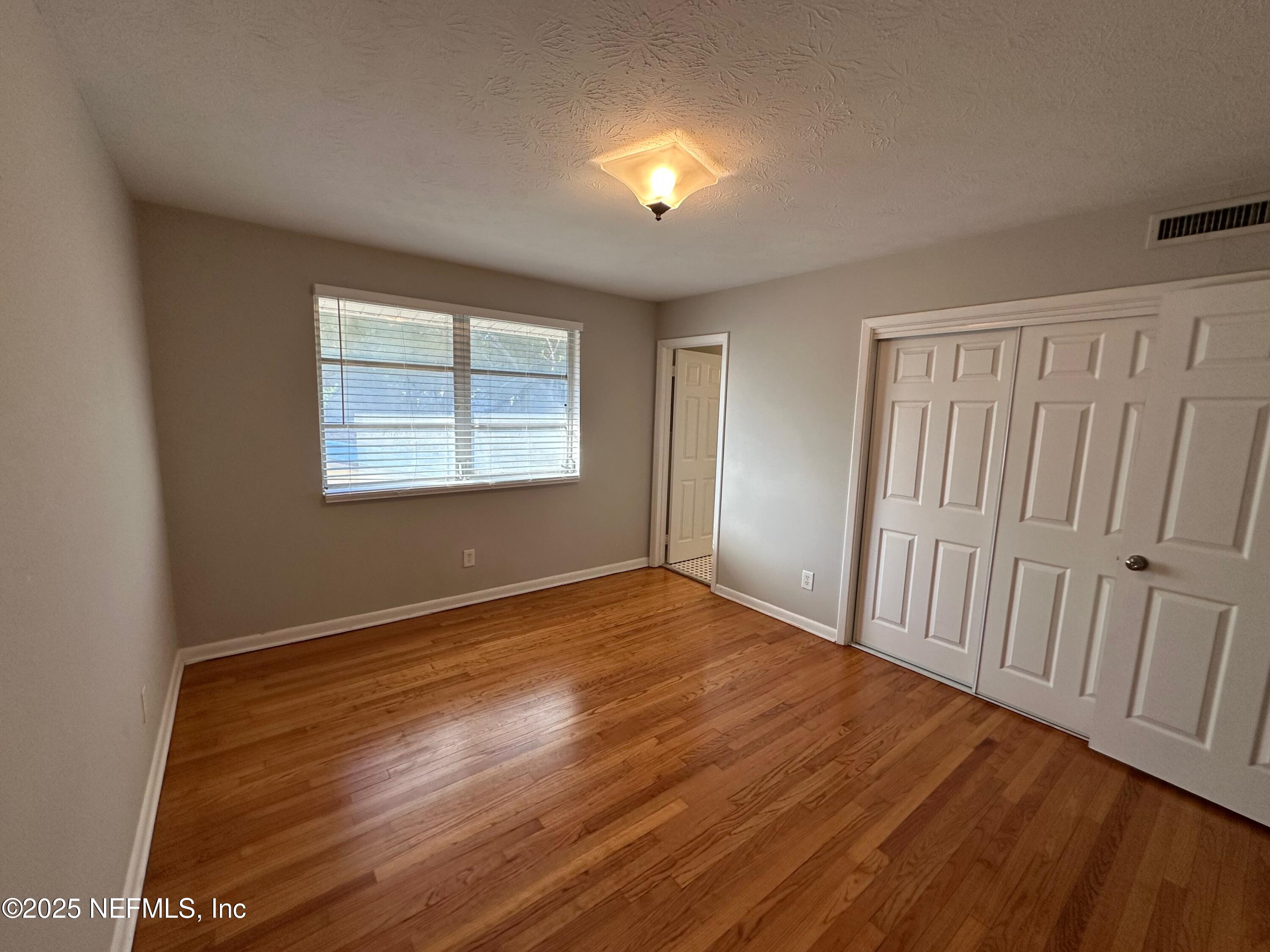 1120 Cedar Street, Unit F Jacksonville, FL 32207 - Photo 18 of 19 a view of an empty room with wooden floor and a window